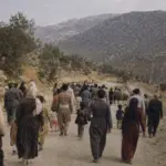 گروهی از مردم در حال حرکت در جادهای کوهستانی در کردستان