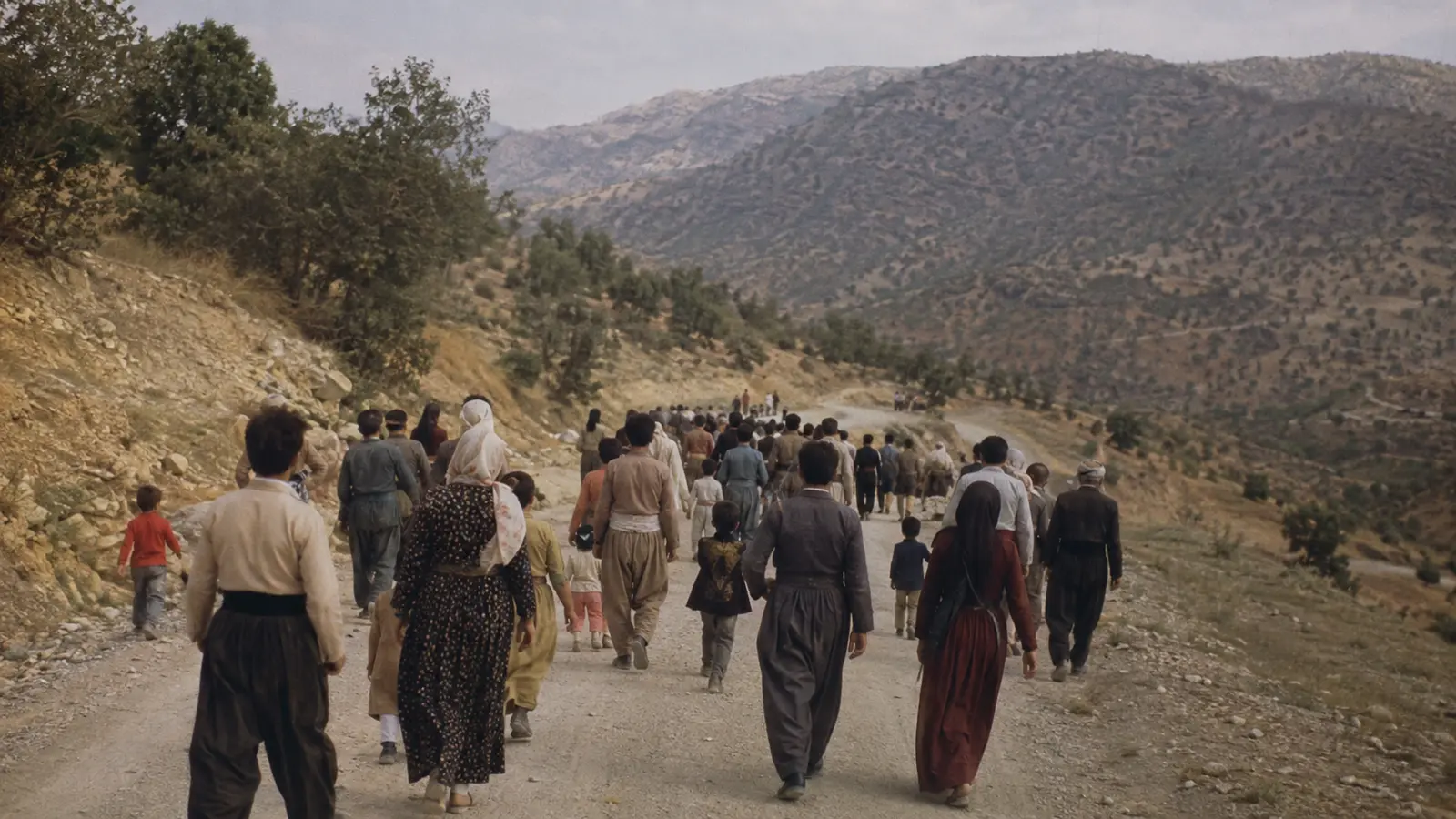 گروهی از مردم در حال حرکت در جادهای کوهستانی در کردستان